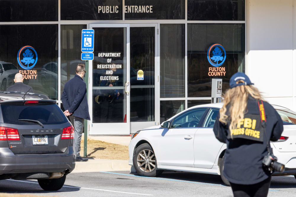 An FBI press office person approaches the Fulton County Election Hub and Operation Center on Jan. 28, 2026, in Union City, Ga.