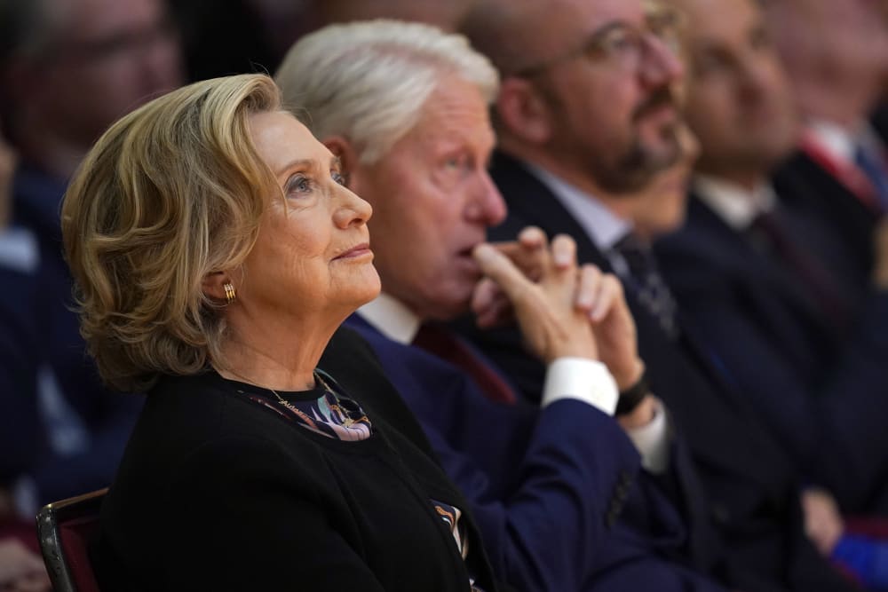 Hillary Clinton, left, and Bill Clinton sit during a conference.