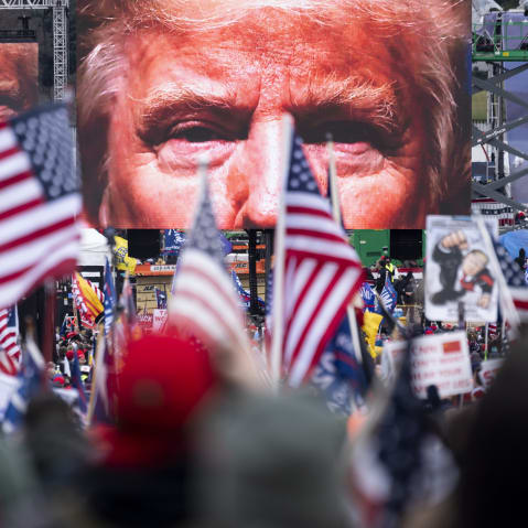 President Trump's closeup photo seen on video screens in front of a crowd at a rally.