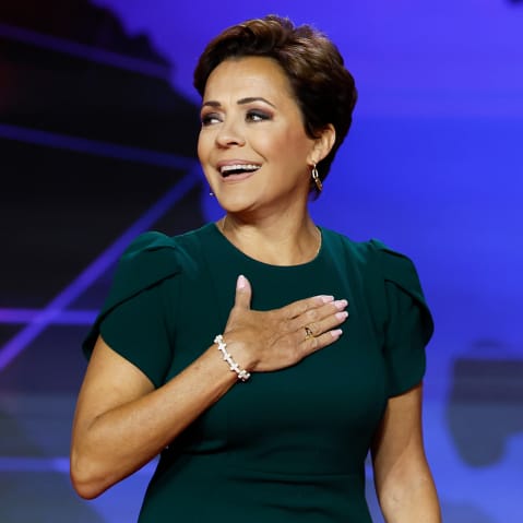 Kari Lake holds her hand on her chest.