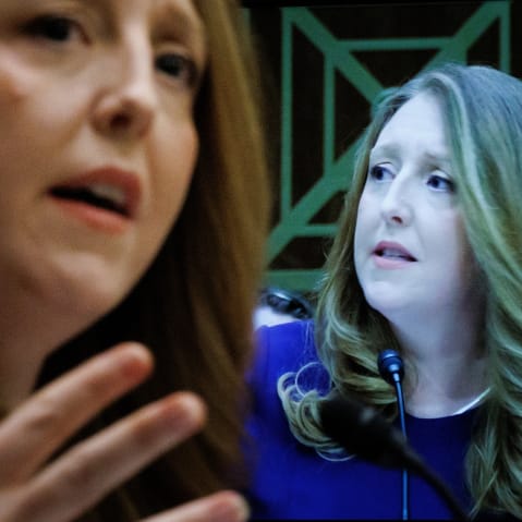 Casey Means in seen out of focus on the left side of the frame while her face is shown on a screen on the right - in focus.