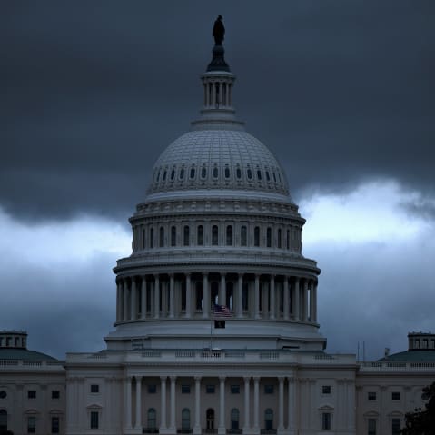 The Capitol building with dark, ominous clouds in the background.