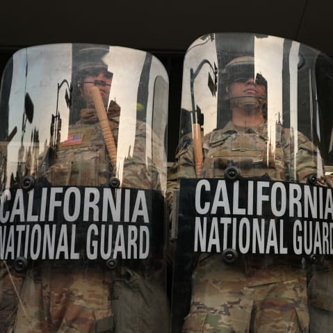 California National Guard stand behind shields on the steps of the Federal Building in Los Angeles.