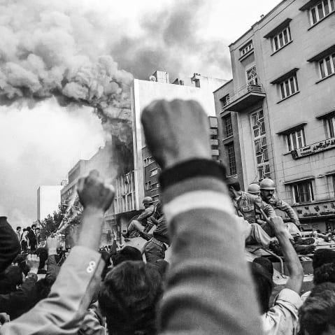 Troops loyal to Shah Mohammad Reza Pahlavi arrive to control a crowd of demonstrators outside a burning government building at the height of Islamic revolutionary fervor on Nov. 4 1978 in Tehran.