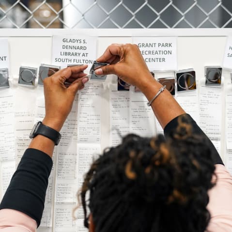 Receipts from early voting are brought out during election night at the Fulton County Elections Hub and Operation Center in Fairburn, GA.