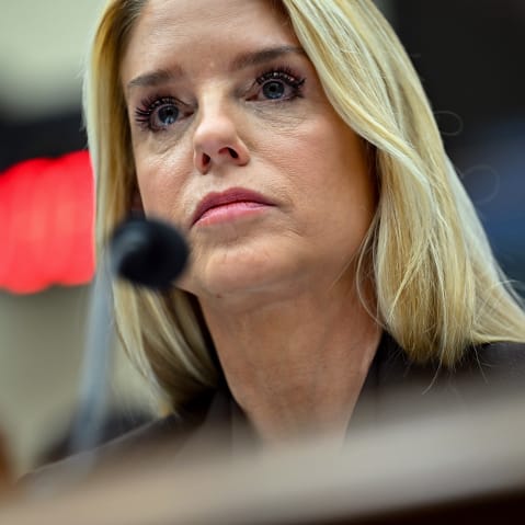 A close up of Pam Bondi behind a microphone.
