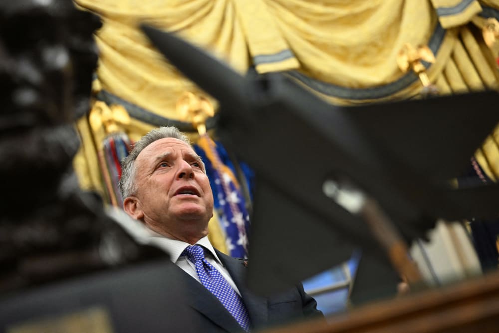 Steve Witkoff speaks in the Oval Office, seen in focus behind a statue of a jet in the foreground.