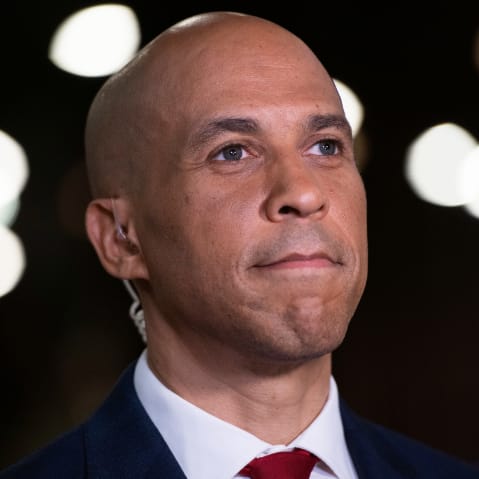 A close up of Cory Booker smiling subtly.