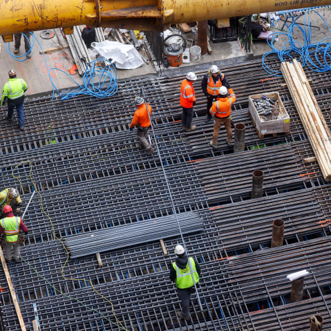 Construction workers are seen from above as they work.