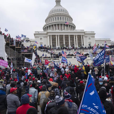 Protesters rush toward the Capitol building.