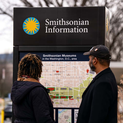 Two people look at a permanent map titled "Smithsonian Museums in the Washington, D.C., area."