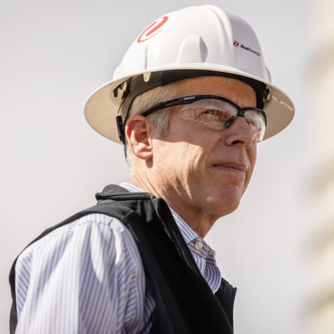 US energy secretary Chris Wright wears a white safety helmet as he walks on the site.
