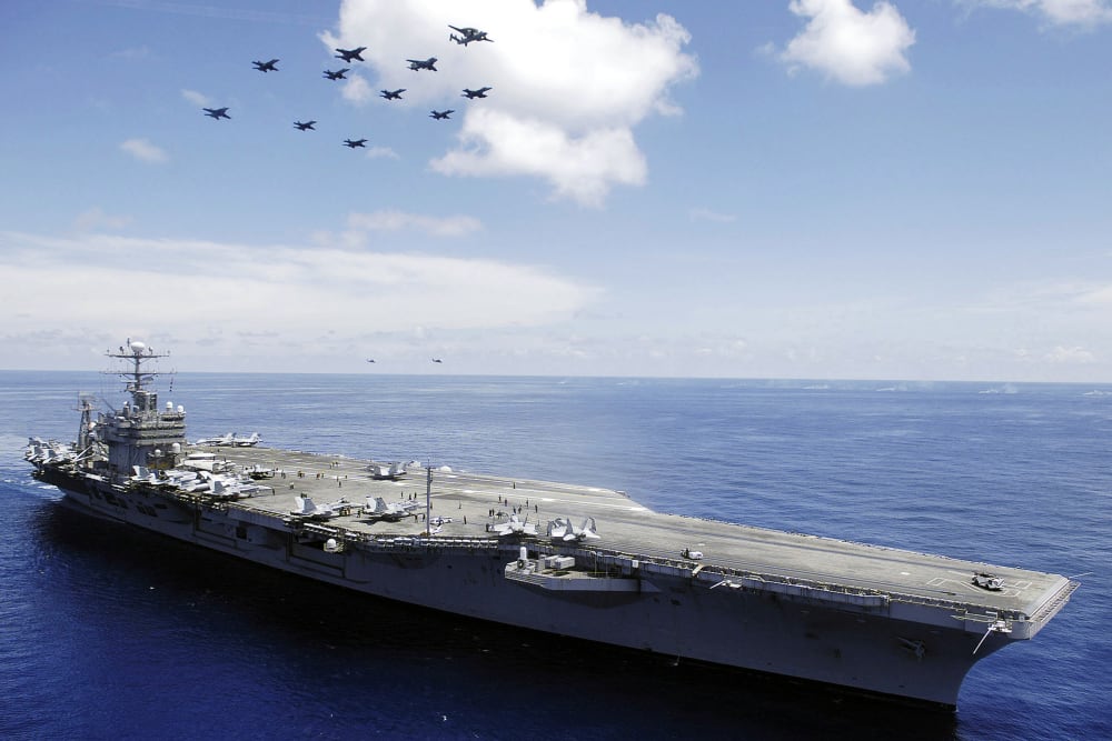 The US Navy (USN) Nimitz-class aircraft carrier USS ABRAHAM LINCOLN (CVN 72) and aircraft assigned to Carrier Air Wing Two (CVW-2) perform an aerial demonstration in the South China Sea.