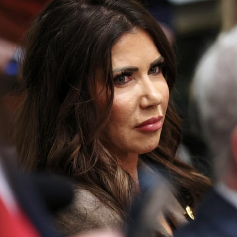 Kristi Noem sits among other cabinet members.