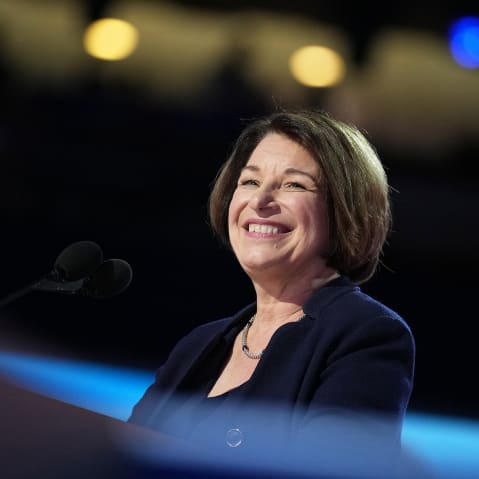 Amy Klobuchar smiles behind a podium.