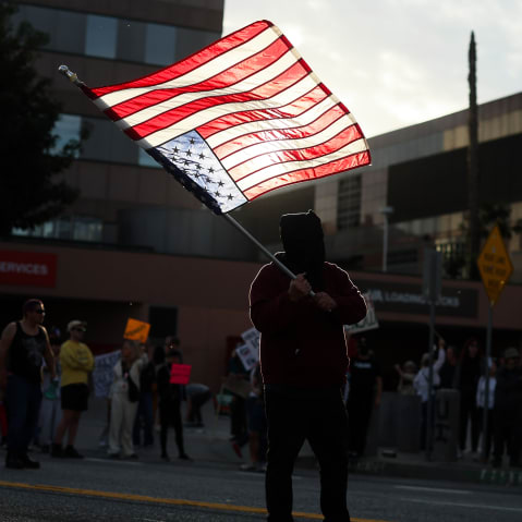 A demonstrator waves an upside-down United States flag in protest of a second shooting death by immigration officers in Minnesota.