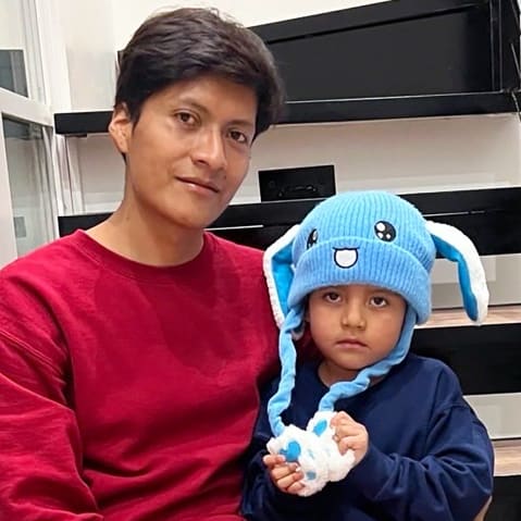 5 year old Liam Ramos, right, sits next to his dad on the steps of a staircase after being released from ICE detention.