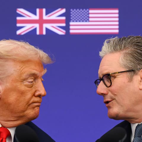 This close-up shot shows Donald Trump, left, and Keir Starmer leaning toward each other from the profile.