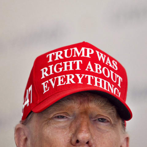 President Donald Trump wears a hat that reads "Trump was right about everything."