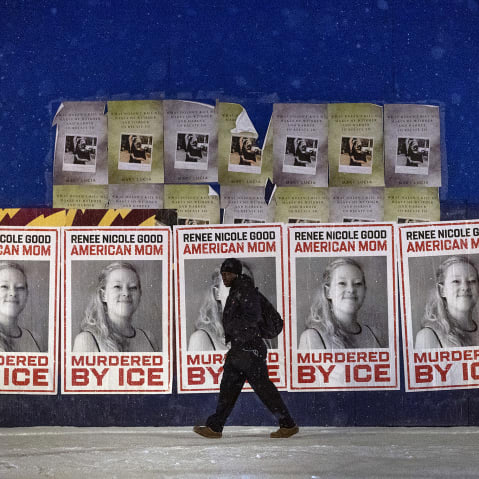 A man walks by a series of posters memorializing Renee Good on Jan. 16, 2026, in Minneapolis.