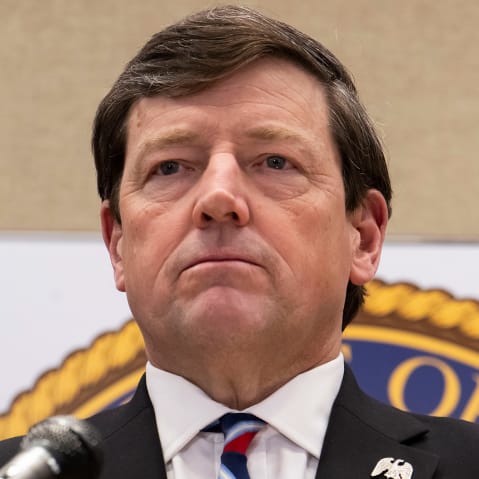 Ed Martin behind a podium with a microphone.