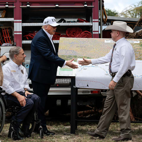 Donald Trump shakes hands with an official at the disaster scene after the deadly flooding in the area.
