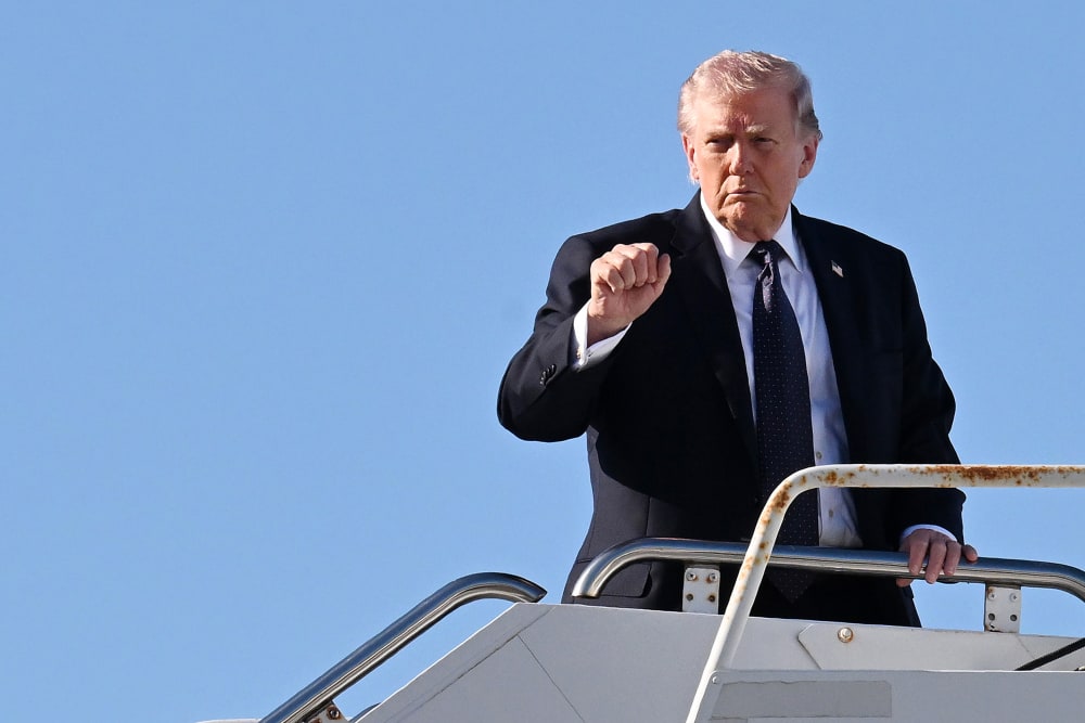 Donald Trump waves as he gets on a plane.