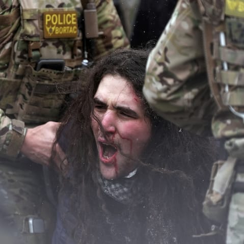 Federal agents detain a person on Jan. 21, 2026, in Minneapolis.