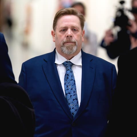 Darren Indyke walks behind two other men.