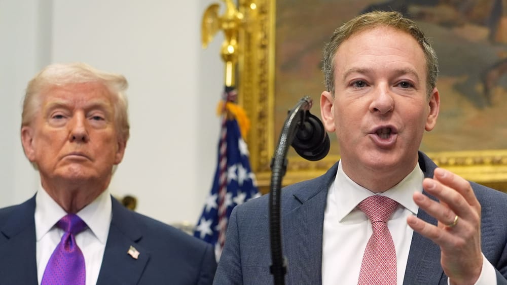 Donald Trump, left, and Lee Zeldin, who speaks into a microphone at a podium.