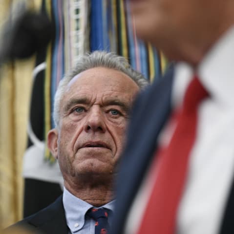U.S. Secretary of Health and Human Services Robert F. Kennedy Jr. listens to President Donald Trump.