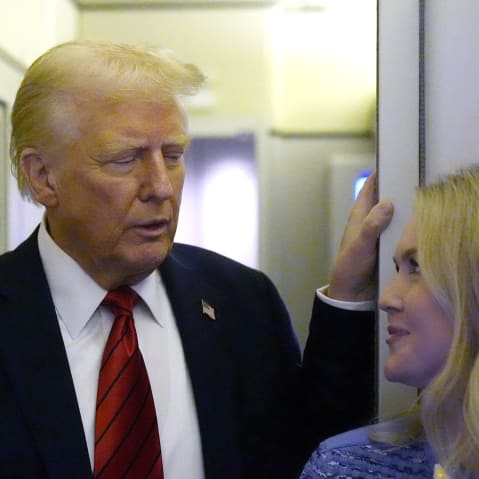 Donald Trump looks at Karoline Leavitt on the plane.