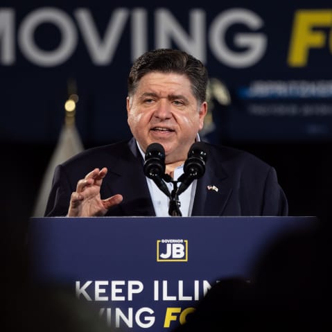 JB Pritzker speaks at a podium that says "Keep Illinois Moving Forward."