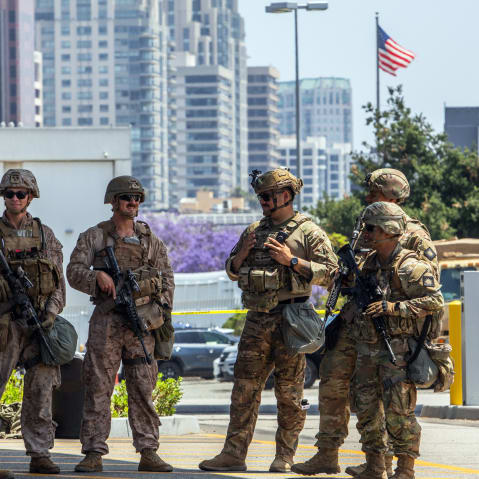 Two U.S. Marines (2nd, 3rd left) stand with California National Guard service members on June 13, 2025 in Los Angeles.