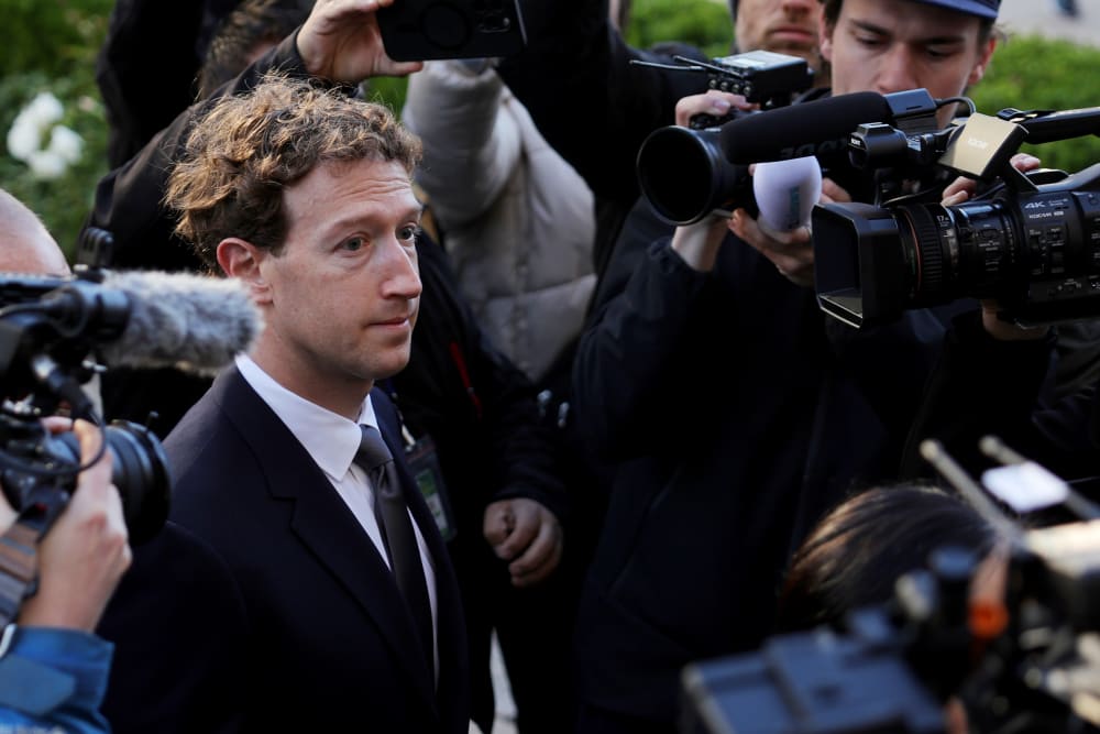Mark Zuckerberg walks towards the courthouse while surrounded with security and media members.