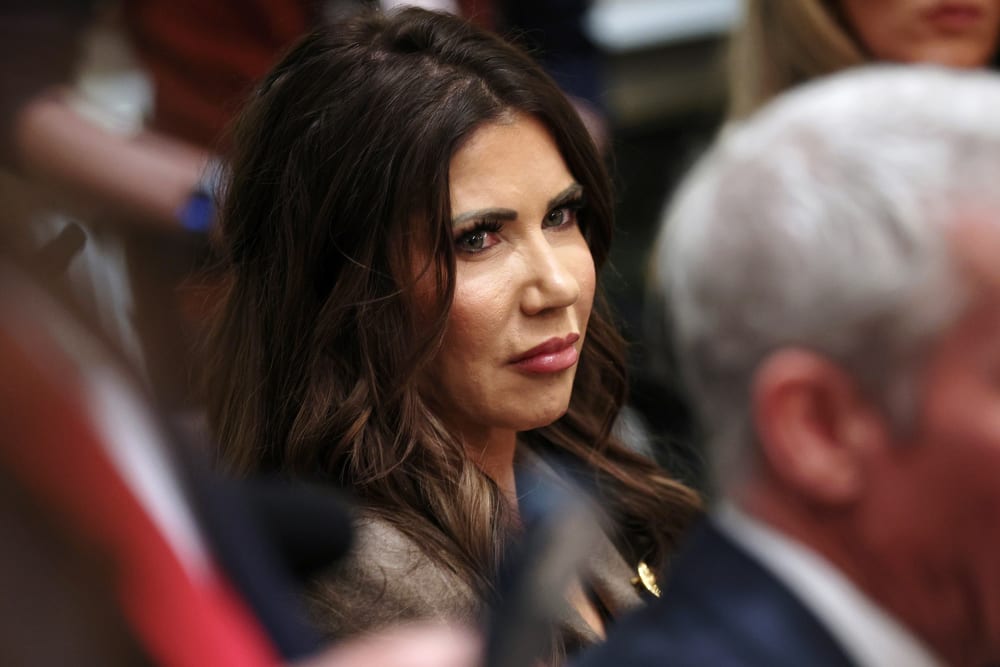 Kristi Noem sits among other cabinet members.