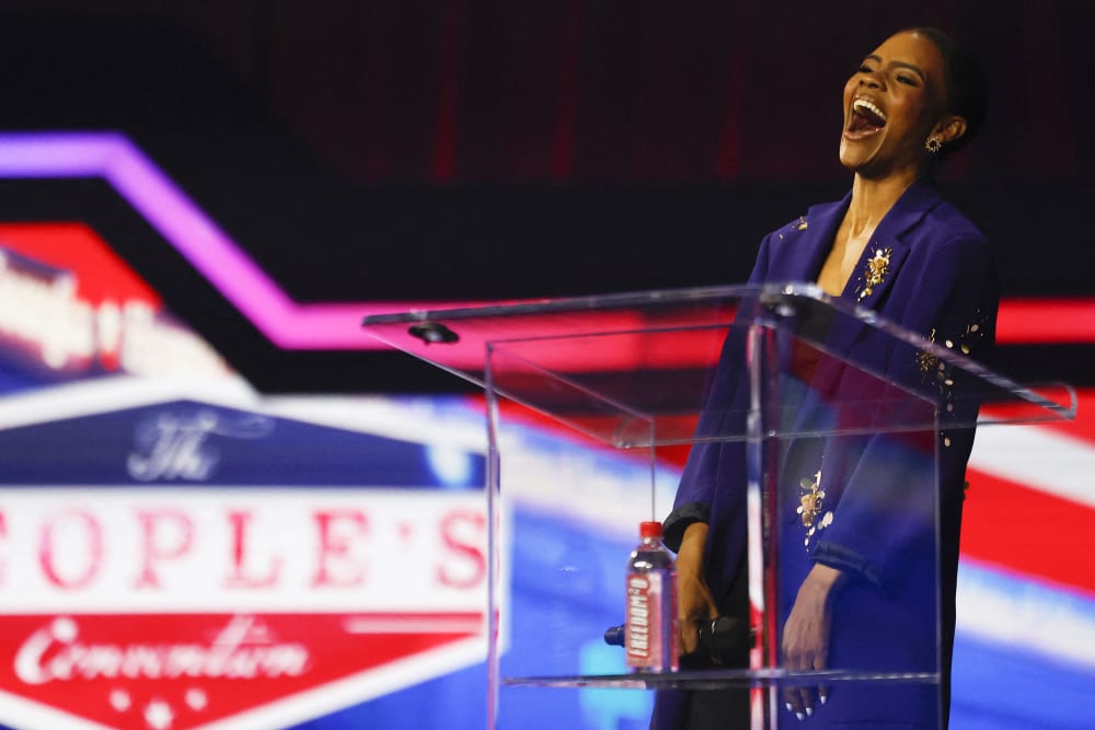 Candace Owens laughs on stage.