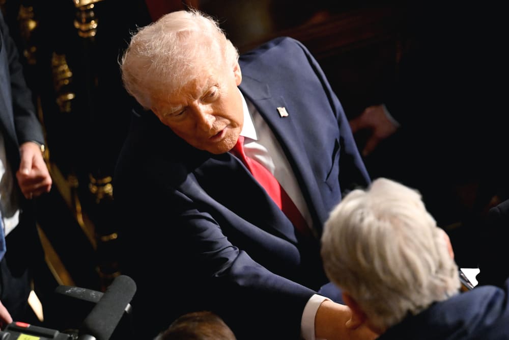 Donald Trump shakes hands with a man in this tilted frame shot from above.
