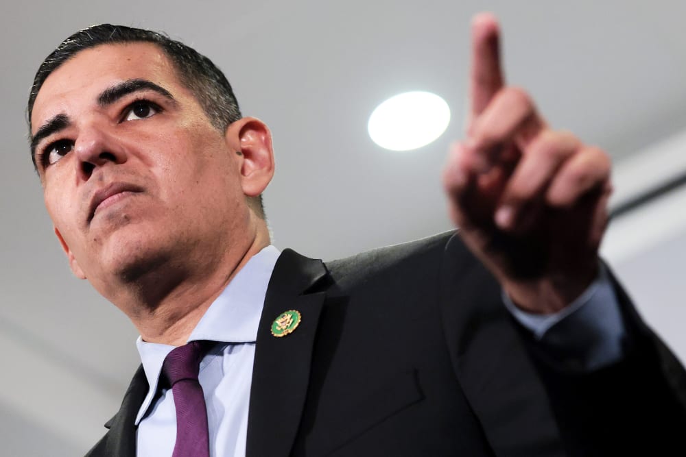 In this photo that was shot from below, Robert Garcia points his left index finger at something or someone. He looks at the same direction.