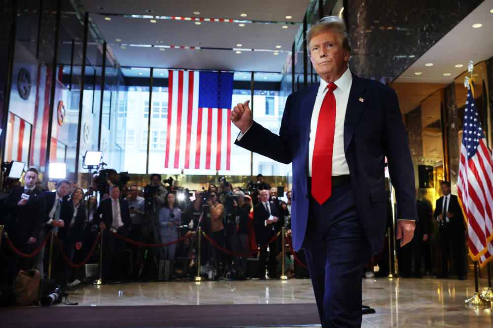 Donald Trumps poits at the journalists behind him.