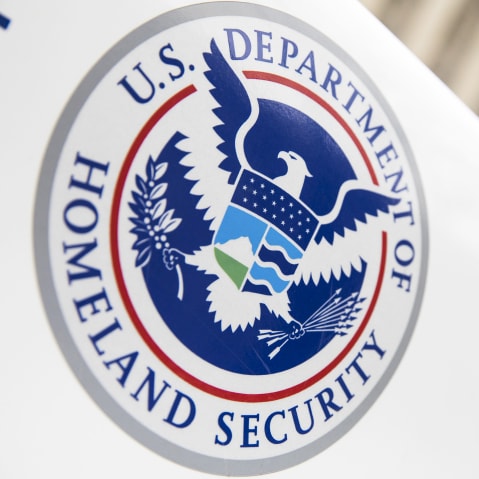 A closeup of DHS logo is seen on a vehicle in a diagonal angle.