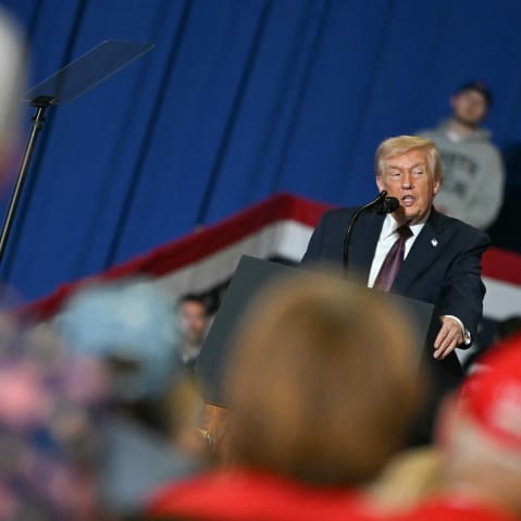 In a tilted frame, Donald Trump is seen speaking in front a small crowd in North Carolina.