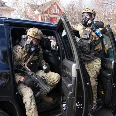 Federal agents get ready to disperse tear gas into a crowd at a protest on Jan. 12, 2026 in Minneapolis.