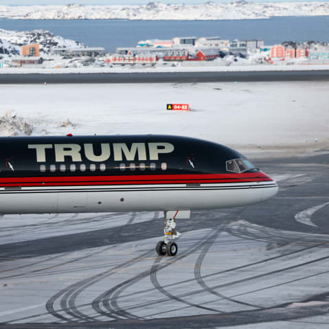 A plane with "TRUMP" written on the side sits on a snowy tarmac.