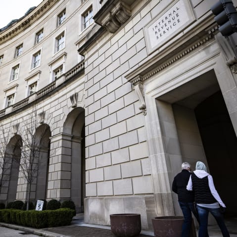 Pedestrians walk in front of the IRS headquarters on March 19, 2021, in Washington, D.C.