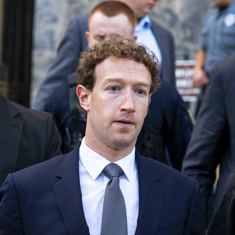 Mark Zuckerberg surrounded by others.