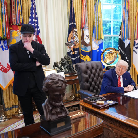 Tesla CEO Elon Musk and U.S. President Donald Trump listen to a question from reporters in the Oval Office.
