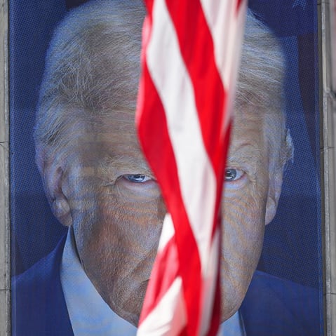 A banner showing an image of President Donald Trump behind a US flag outside the Department of Agriculture building.