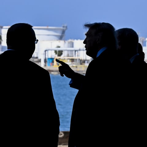 Donald Trump is seen pointing at something in this photo that shows silhouettes of his and other men.