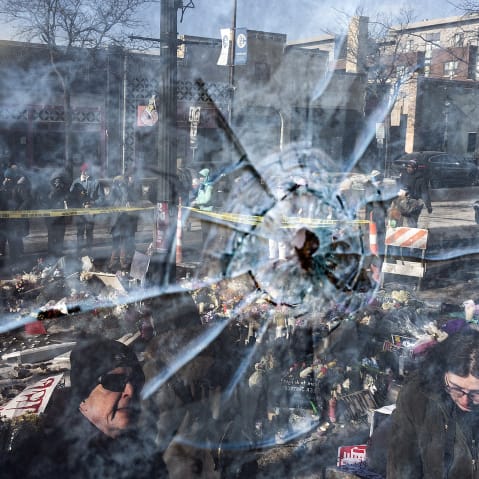 A gun shot perforation in a window pane in front of a makeshift memorial for Alex Pretti in Minneapolis.